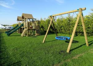 a playground with two swings and a slide at Kings Lynn Holiday Park in King's Lynn