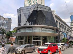 クアラルンプールにあるDorsett Residence KL Private Studio apartmentの前に車が駐車されている大きな建物