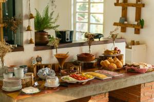 ein Buffet mit vielen verschiedenen Speisen auf der Theke in der Unterkunft Pousada Recanto das Rosas in Bragança Paulista