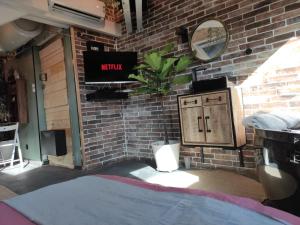 a room with a brick wall with a toilet and a mirror at La cachette sous les toits balnéo climatisé in Nantes
