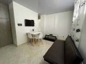 Habitación con cama, mesa y TV. en Hermoso apartamento completo 2 habitaciones - ubicación excelente para transporte al parque del café y PANACA, en Armenia