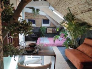 a living room with a couch and a table at La cachette sous les toits balnéo climatisé in Nantes