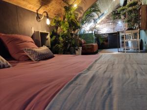 a large bed in a room with plants at La cachette sous les toits balnéo climatisé in Nantes