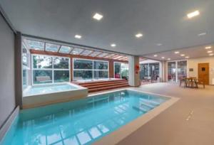 uma grande piscina com banheira numa casa em Hotel Laghetto Stilo Borges em Gramado