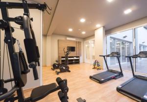 a gym with treadmills and machines in a room at Hotel Laghetto Stilo Borges in Gramado