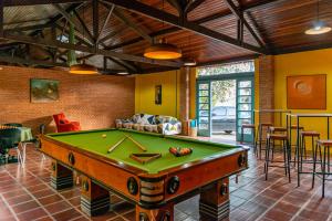 a room with a pool table in the middle of it at Pousada Recanto das Rosas in Bragança Paulista