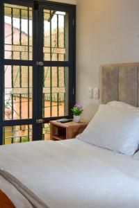 a bedroom with a white bed and a window at Casa Lorenza Hotel in Cartagena de Indias