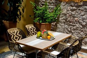 a wooden table with a plate of fruit on it at Casa Lorenza Hotel in Cartagena de Indias +42 photos