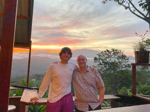 Due uomini che posano per una foto davanti a una montagna di Bella Vista Ranch Ecolodge a Turrialba