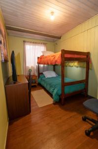 a bedroom with a bunk bed and a television at Hostal Sol Temuco in Temuco