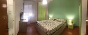 1 dormitorio con cama y pared verde en Residence Corso 50, en Mestre