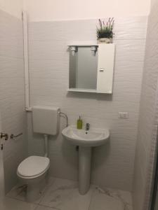 Baño blanco con aseo y lavamanos en Residence Corso 50, en Mestre