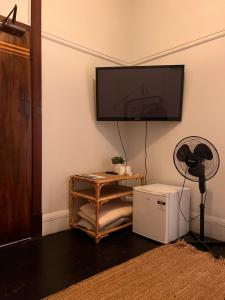 um quarto com uma televisão de ecrã plano na parede em Charing Cross Hotel em Sydney