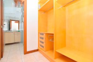 Habitación con armario con estanterías de madera y cocina. en Pousada ESQUINA DO ATLANTICO SUL en Tubarão