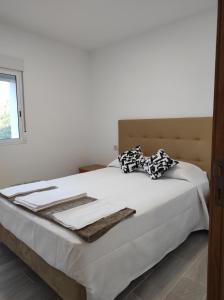 una camera da letto con un letto con lenzuola bianche e una finestra di Casa do Vale - Casa Termal - Gerês/Xures a Lobios
