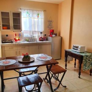 a kitchen with a table and chairs and a kitchen with a refrigerator at Como el Calor de tu hogar in San Pedro Sula