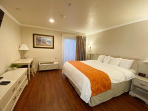 a hotel room with a large bed and a desk at Monarch Valley Inn Marina at Monterey Bay in Marina