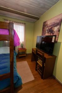 a bedroom with a bunk bed and a flat screen tv at Hostal Sol Temuco in Temuco