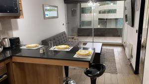 Departamento a pasos de Clinica Las Condes- Estoril في سانتياغو: مطبخ مع طاولة عليها صحون طعام