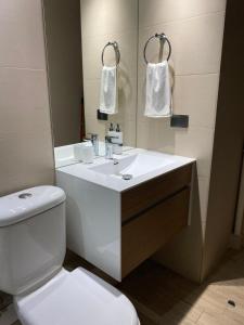a bathroom with a white toilet and a sink at Departamento a pasos de Clinica Las Condes- Estoril in Santiago