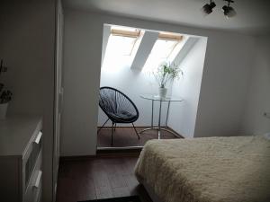 a bedroom with a table and a chair and a window at Lovely loft in Cluj-Napoca
