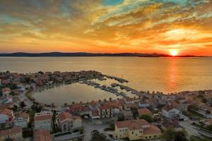 eine Luftansicht einer Stadt mit Yachthafen bei Sonnenuntergang in der Unterkunft Seaside holiday house Bibinje, Zadar - 5854 in Bibinje