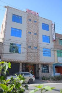 a building with a car parked in front of it at Hostal El Gran Marquez G&J in Urbanizacion Buenos Aires