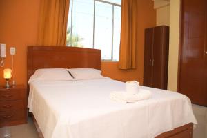 a bedroom with a bed with a roll of toilet paper on it at Hostal El Gran Marquez G&J in Urbanizacion Buenos Aires