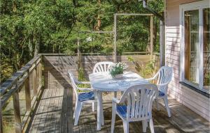 una mesa blanca y sillas en un porche en Nice Home In Yngsj With 2 Bedrooms, en Yngsjö