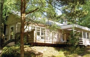 a large white house with a porch and trees at Two-Bedroom Holiday Home In Yngsjo in Yngsjö