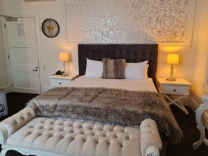 una camera da letto con un grande letto con una coperta marrone di Hotel D'urville Blenheim a Blenheim
