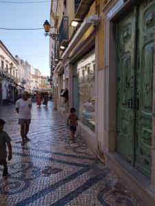 Una mujer y dos niños caminando por una calle en St. António 49 en Faro