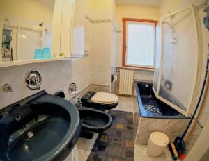 ボルミオにあるIl Balcone Delle Alpiのバスルーム(黒い洗面台、トイレ2つ付)