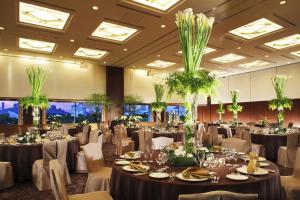 um salão de banquetes cheio de mesas e cadeiras com plantas em Tokyo Bay Ariake Washington Hotel em Tóquio