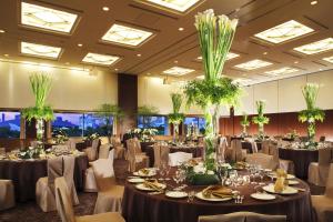 a banquet hall filled with tables and chairs with plants at Tokyo Bay Ariake Washington Hotel in Tokyo