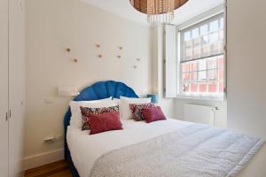 a bedroom with a bed with a blue headboard and a window at BOUTIQUE Rentals- DOURO Ribeira historical center with parking in Porto