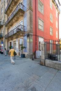 een man die door een straat loopt voor een gebouw bij BOUTIQUE Rentals- DOURO Ribeira historical center in Porto