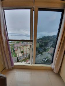 een raam met uitzicht op de stad bij Breezy Nest Staycation at Wind Residences Tagaytay in Tagaytay