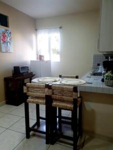 a kitchen with a counter with two bar stools at Hermoso Apartamento in San Pedro Sula