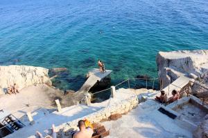 a group of people sitting on steps near the water at Apartments with a parking space Marusici, Omis - 1041 in Mimice