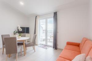 Apartments by the sea Duce, Omis - 8378 في دوغي رات: غرفة معيشة مع طاولة وأريكة