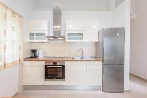 een keuken met witte kasten en een roestvrijstalen koelkast bij Apartments by the sea Duce, Omis - 8378 in Dugi Rat