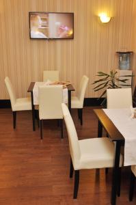 Un comedor con sillas blancas y una mesa. en Hotel Business Apartments, en Dnipro