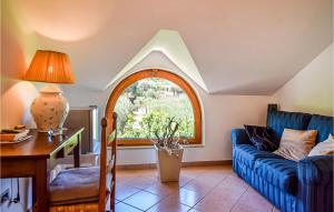 a living room with a blue couch and a window at Stunning Home In S M Di Castellabate in Santa Maria di Castellabate