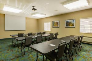 a conference room with tables and chairs and a whiteboard at Candlewood Suites Springfield South, an IHG Hotel in Springfield