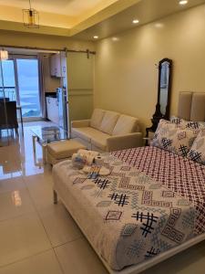 een slaapkamer met een bed en een woonkamer bij Breezy Nest Staycation at Wind Residences Tagaytay in Tagaytay