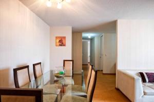 a dining room with a glass table and chairs at Departamento céntrico y moderno, exelente ubic. in Lima