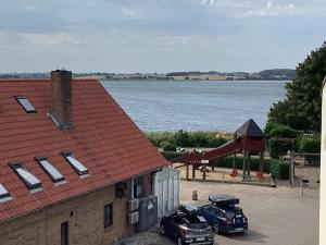 a view of a building with a playground next to a body of water at 4 person holiday home in Hejls-By Traum in Hejls