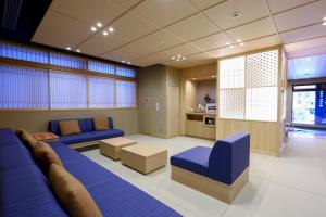 Onyado Nono Sendai Natural Hot Spring في سيندايْ: غرفة معيشة مع أرائك زرقاء وطاولة