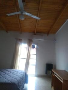 a bedroom with a ceiling fan and a window at Casa tipo duplex con patio y parrilla. Muy cómoda in Neuquén